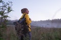 Caucasian woman walking in field alone. Girl in sport clothes hiking with backpack. Royalty Free Stock Photo