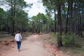 Caucasian woman 40-50 walking on a forest near Albarracin, Teruel. View of her back, white shirt and blue jeans. Spain Royalty Free Stock Photo