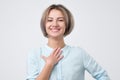 Caucasian woman wearing blue shirt smiling broadly glad to receive compliments from friends