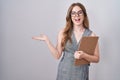 Caucasian woman wearing glasses and business clothes pointing aside with hands open palms showing copy space, presenting Royalty Free Stock Photo