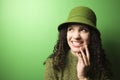 Caucasian woman wearing green clothing and hat.