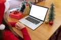 Caucasian woman wearing santa hat having video call on laptop with copy space at christmas time Royalty Free Stock Photo