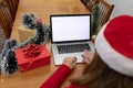 Caucasian woman wearing santa hat having video call on laptop with copy space at christmas time Royalty Free Stock Photo