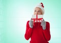 Caucasian woman wearing santa hat holding christmas gift against copy space on green background Royalty Free Stock Photo
