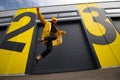 Caucasian woman wearing a yellow hat and a yellow raincoat jumping on a city street, positive active lifestyle and street