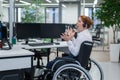 Caucasian woman in a wheelchair yells. Nervous breakdown female call center worker. Royalty Free Stock Photo
