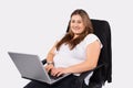 Caucasian woman working on laptop sitting in office. Overweight young woman staying at home during quarantine. Self