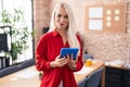 Caucasian woman working at the office with tablet puffing cheeks with funny face