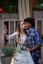 Caucasian woman and afro-american man taking selfie  in a outdoor bar. multiethnic, friends, couple, concept Royalty Free Stock Photo