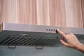 Caucasian women hand using the range hood in modern kitchen