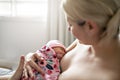 Woman in her bedroom breastfeed her baby.