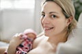 Woman in her bedroom breastfeed her baby.