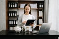 Caucasian Women are putting coins in a piggy bank for a business that grows for profit and saving money for the future. planning Royalty Free Stock Photo