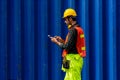 Caucasian worker in safety vest reflective with Safety helmet walking and typing on tablet