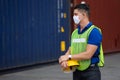 Caucasian worker in safety vest reflective holding Safety helmet with Surgical mask at work