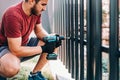 caucasian worker working with an electric screwdriver on the construction site Royalty Free Stock Photo