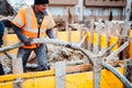 Workers pouring concrete with concrete pump. Details of construction site and close up details of worker workwear