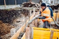 workers pouring concrete with concrete pump and hose. Details of construction site and close up details of worker