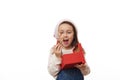 Caucasian child girl in Santa hat, holding striped green red candy cane, rejoicing while unpacking Christmas presents Royalty Free Stock Photo