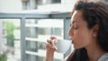 Caucasian young attractive housewife sitting on a balcony enjoying morning and drinking coffee. Close up of beautiful Royalty Free Stock Photo