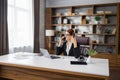 Caucasian young beautiful businesswoman talking on mobile phone while working on laptop Royalty Free Stock Photo