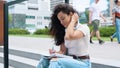 Caucasian young beautiful female student sitting on stairs outdoors near college or university and writing in her Royalty Free Stock Photo