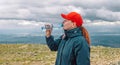 Caucasian young blonde girl drinking water from plastic bottle. mountain background.