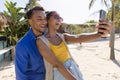 Caucasian young couple laughing and takine selfie over smartphone at beach Royalty Free Stock Photo