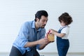 Caucasian young dad with beard smiling giving gift box to little cute daughter. Family sitting in living room at home celebrating Royalty Free Stock Photo