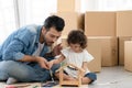 Caucasian young father sitting on floor and holding little kid girl`s hand to hold paintbrush teach daughter paint water color Royalty Free Stock Photo