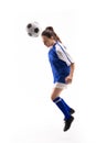 Caucasian young female soccer player heading soccer ball while playing against white background Royalty Free Stock Photo