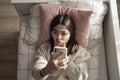 Caucasian young girl making selfie and lying in her bed Royalty Free Stock Photo