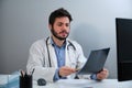 Young doctor looking amazed at a X-ray of a pelvis and spinal column. Royalty Free Stock Photo