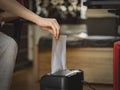 Caucasian young man inserts a sheet of paper for destruction in a black shredder Royalty Free Stock Photo