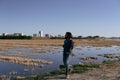 Caucasian young man with long hair imitating a guitar player on the outskirts of the city on a clear day