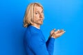 Caucasian young man with long hair presenting with open palms, holding something depressed and worry for distress, crying angry Royalty Free Stock Photo