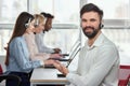 Caucasian young man pointing at his co-workers in call center. Royalty Free Stock Photo