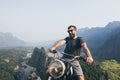 Caucasian young man riding motorcycle on top of the mountains in Vang Vieng, Laos Royalty Free Stock Photo