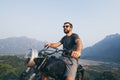 Caucasian young man riding motorcycle on top of the mountains in Vang Vieng, Laos Royalty Free Stock Photo