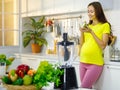 Caucasian young pregnant female mother in casual outfit with big belly tummy standing smiling holding vegetarian salad bowl eating Royalty Free Stock Photo