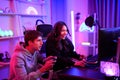 Caucasian young streamer boy and Asian influencer girl playing video game online while broadcast live on their channel for review Royalty Free Stock Photo