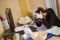 Stressed woman at work with computer in front of her