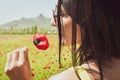 Caucasian young woman hold poppy flower close to face in summer field happy outdoors. Concept freedom and summer joy in nature Royalty Free Stock Photo