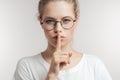 Caucasian young woman holding her finger to her lips calling to keep silence. Royalty Free Stock Photo