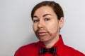 Caucasian young woman with painted beard. Wearing lake a man in red shirt and a bow tie. Male hairstyle Royalty Free Stock Photo