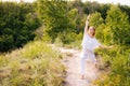 Caucasian young woman practicing yoga on park outside the city. Meditative lady enjoying meditation Royalty Free Stock Photo