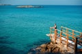 Woman standing on pier near rough stones and waving sea Royalty Free Stock Photo