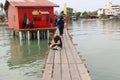 Caucasian young woman using her smartphone on narrow wooden pier