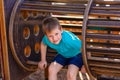 Caucasoid sporty cheerful boy playing on a wooden Playground