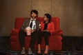 Couples sit together in the cinema with movie tickets and popcorn.